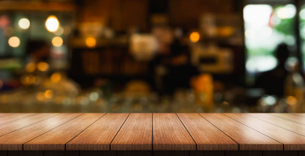 istock Empty wooden table top with lights bokeh on blur restaurant background. 1480974986