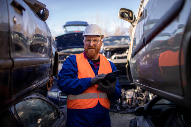 trabalhador do sexo masculino em um ferro-velho automotivo - recycling center junkyard car scrap metal - fotografias e filmes do acervo