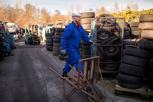 Male worker in an automotive junkyard