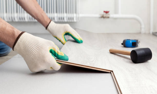 istock Man in protective gloves lays a laminate on the floor. 1480979010
