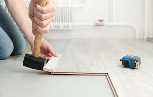 istock Man lays a laminate on the floor, hammering it with a rubber mallet. 1480979012