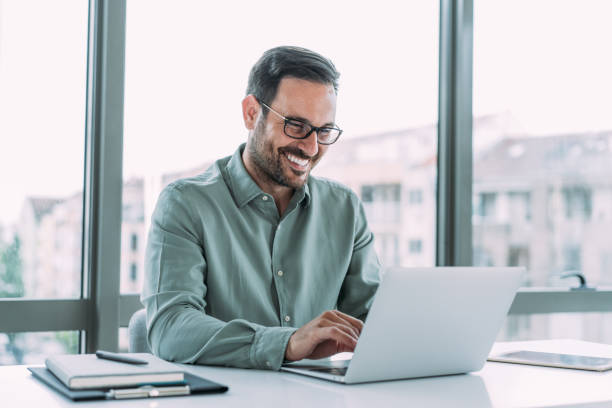istock Successful businessman in modern office working on laptop. 1480979224