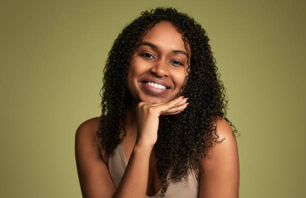 istock Optimistic Hispanic woman with curly hair smiling in studio 1480981832