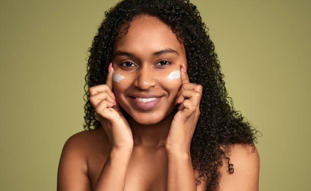 istock Smiling black woman applying eye cream 1480981862