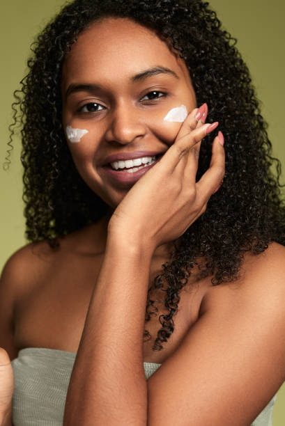 istock Smiling Hispanic woman applying cream on cheeks 1480981869