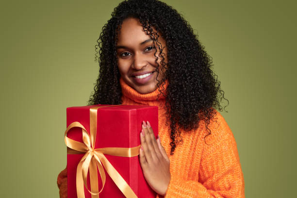 istock Smiling African American woman with present box in studio 1480981872
