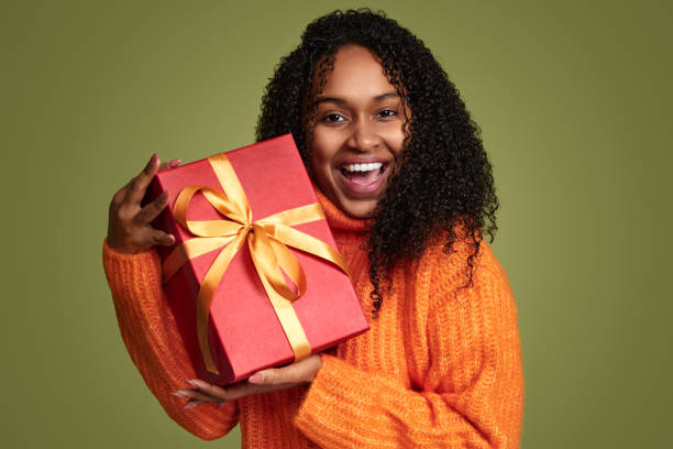 istock Smiling ethnic woman with present in studio 1480981884