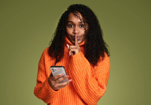 istock Young Hispanic woman using smartphone and showing silence gesture 1480981913