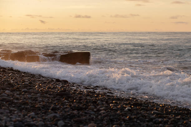 istock Splashing waves on the pebbly beach On the Sunset 1480982427