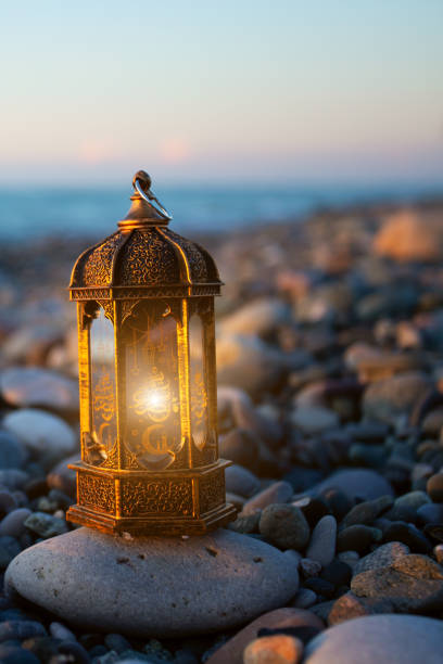 istock ramadan kareem lamp glows on the seashore at sunset,copy space 1480982434