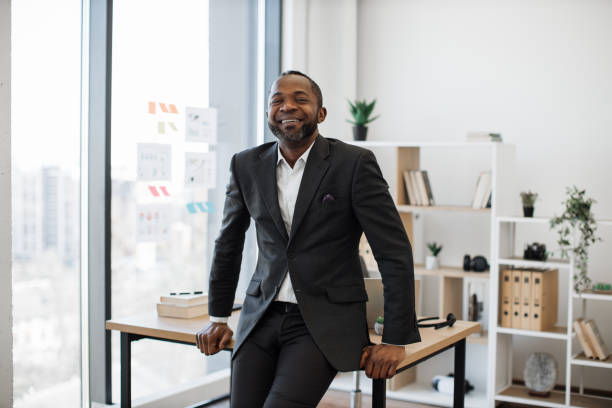 istock Company leader resting on edge of office desk 1480983111