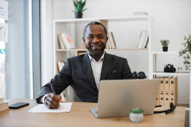 istock Office administrator sitting at writing desk with laptop 1480983662