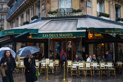 Les Deux Magots, the famous cafe and restaurant in Paris, France on a rainy day. March 24, 2023.