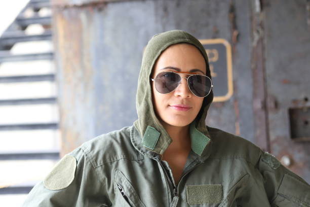 Woman whom is in her United Air Force flight uniform poses in a rustic background.