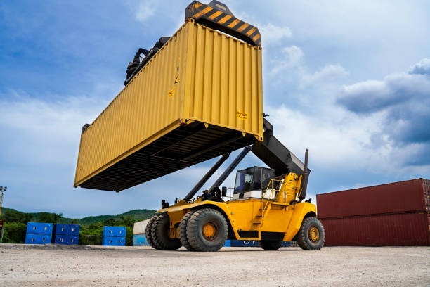 istock forklift Truck working in the container cargo yard port loading cargo tank logistics service and transportation concept. 1480986317