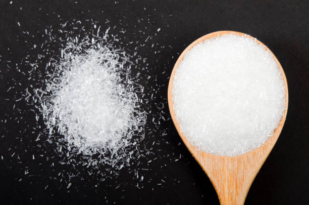 istock The Monosodium glutamate on wooden spoon on black background / MSG 1480987023
