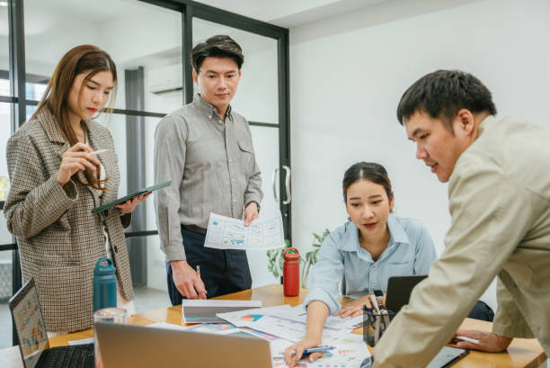 istock Group of young asian business executives talking in office. 1480988264