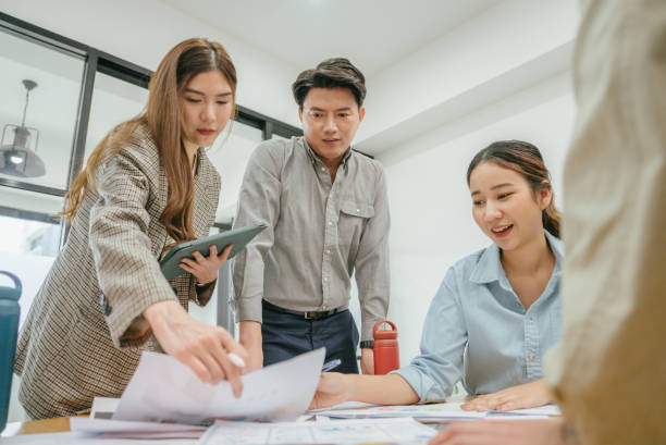 istock Group of young asian business executives talking in office. 1480988285