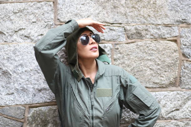 Female Marine in camouflage uniform carrying a duffel bag, walking outside, focusing on homecoming and military service