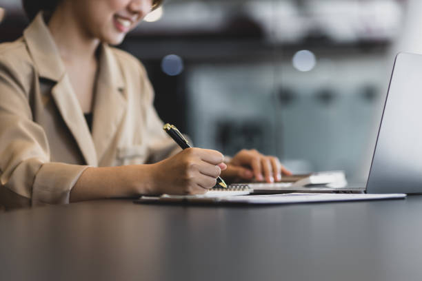 istock Happy businesswoman working with laptop and writing work notes. 1480992496