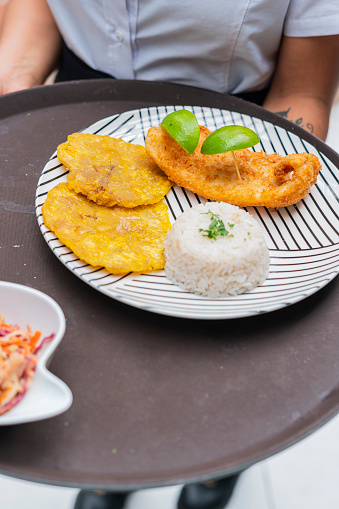 Food plate served with fish, rice and patacon