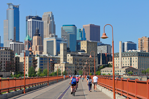 Daytime view of the skyline of Minneapolis as seen from the Stone Arch bridge - a railroad bridge across the Mississippi river - now used as a pedestrian and bicycle pathway.