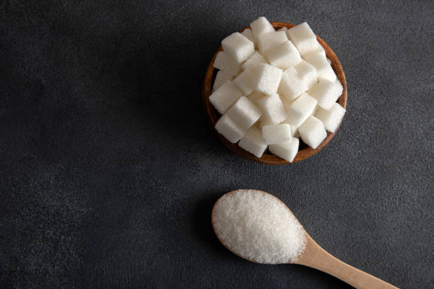 istock Cube sugar and granulated sugar on black background 1480995395