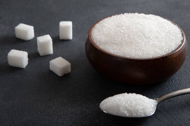 istock Cube sugar and granulated sugar on black background 1480995399