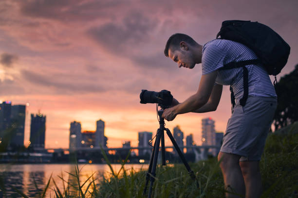 istock Concentrated photographer with camera on tripod at sunset 1480996498