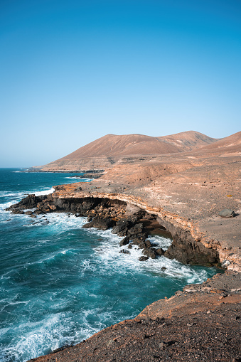 Stunning view of a rocky coastline bathed by a beautiful blue ocean. Playa del Aguila (Eagles' Beach) Fuerteventura, Canary Islands, Spain.