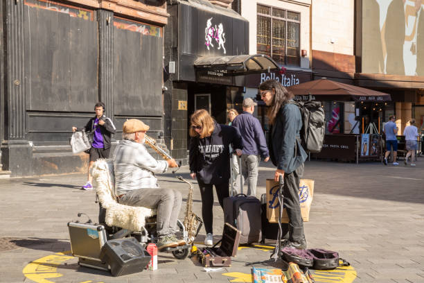 London, United Kingdom - September 24, 2021 - The street musician Guy Stuart showing his saxophone to people at Leicester Square.
