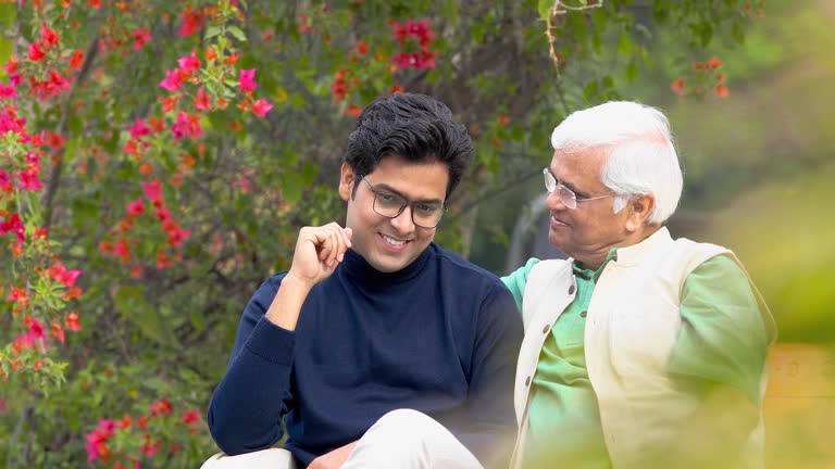 Senior men comforting to his thoughtful son at park