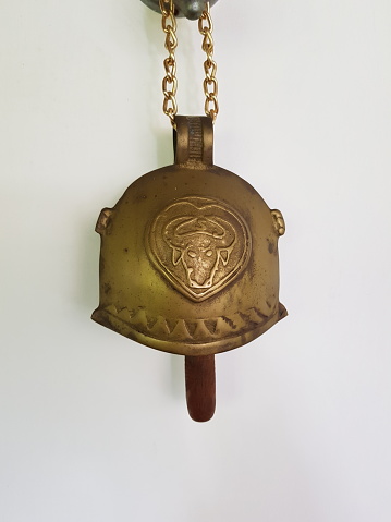 Unused copper bell previously used for bull hanging on the wall for decoration