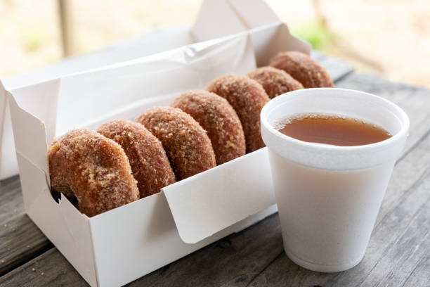 Cup of apple cider and box of cinnamon donuts stock photo