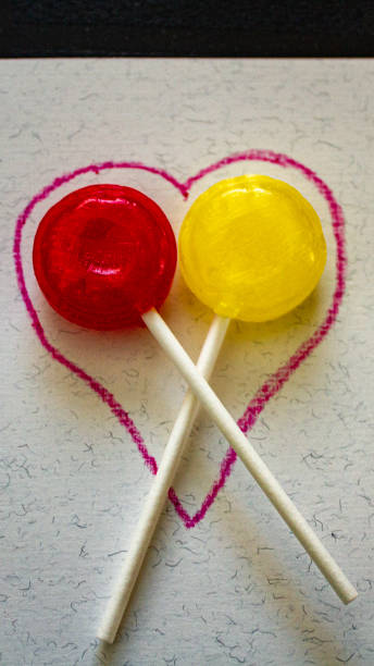 card with red and yellow suckers in a heart shape stock photo