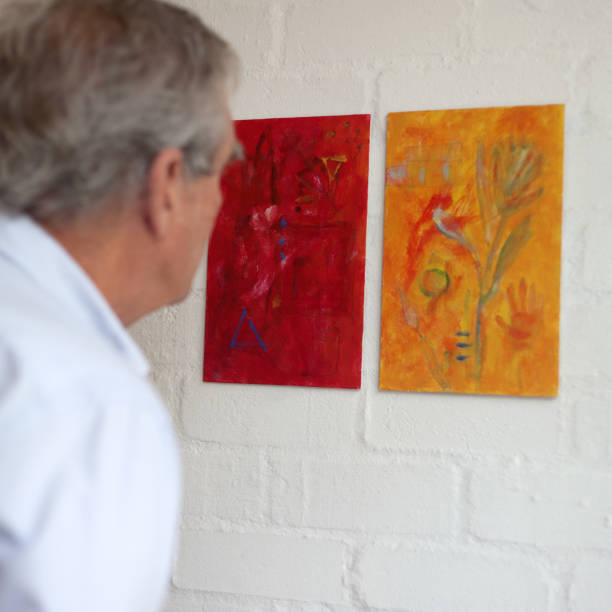Man looking at abstract paintings,