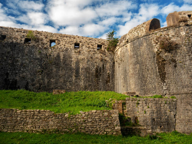 istock Ancient military fortress stone wall and round tower with embrasure under blue sky view from the fort territory 1481008556