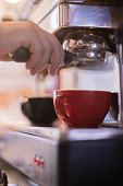 istock Bartender working on coffee machine in red cup and black cup 1481008650