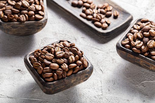 Coffee beans roasted in cup on light background, coffee from Colombia