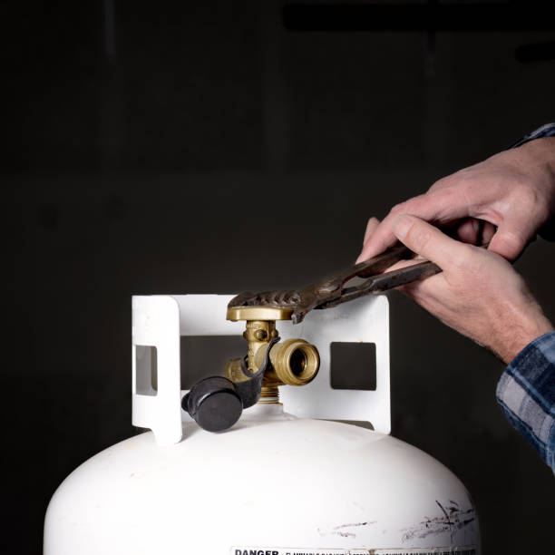 istock Man struggles with pliers on a propane tank 1481011341