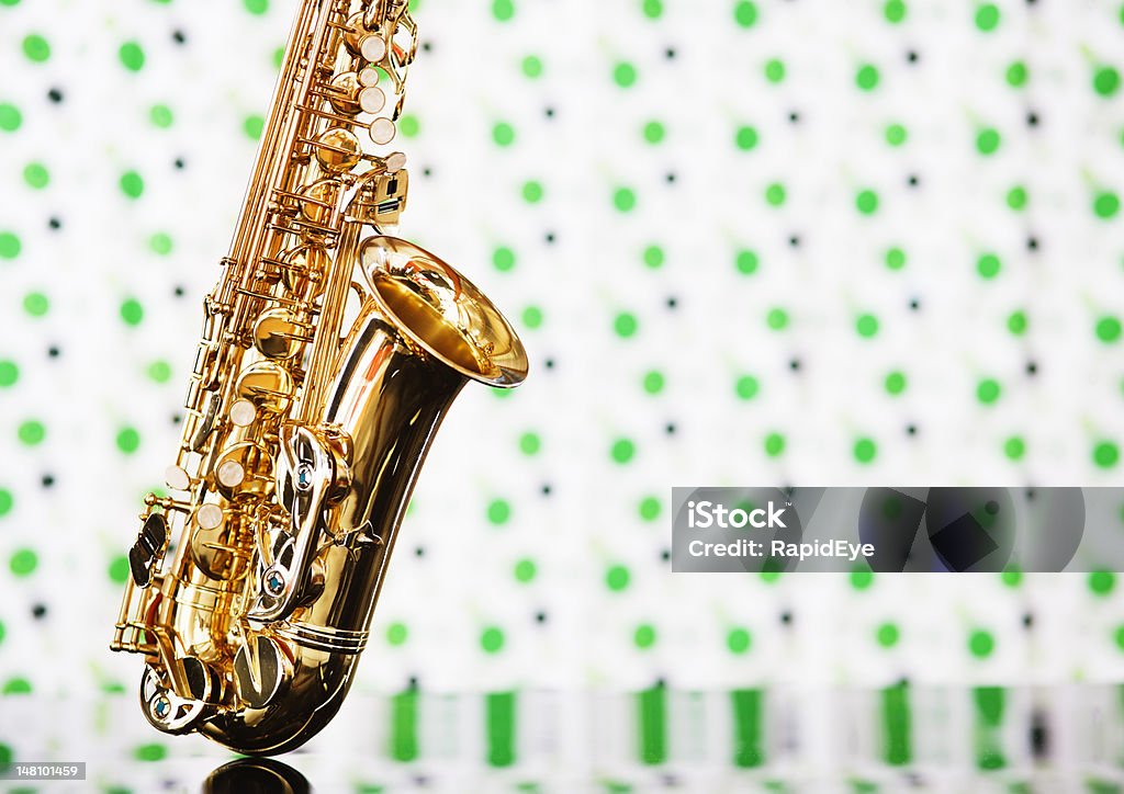 Saxophone on perspex against green and white fabric - Royaltyfri Akrylglas Bildbanksbilder