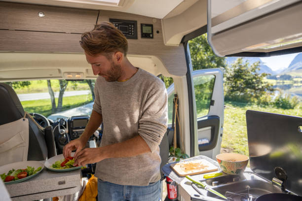 istock Man cooking in a van, lake view 1481016866