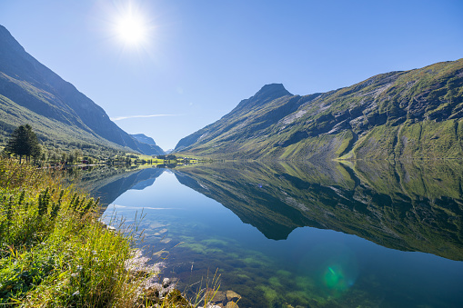 Sunny day with no clouds, reflection on the water surface. Pristine clear water.