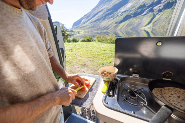 istock Man cooking in a van, lake view 1481017098