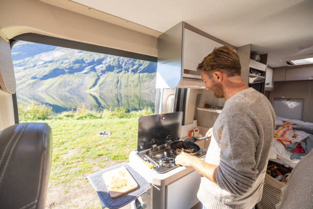 istock Man cooking in a van, lake view 1481017678