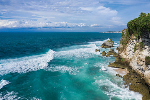 Coastal view of waves breaking along the shore in South Bali in Indonesia.
