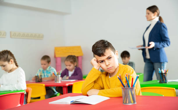istock Portrait of tired schoolboy sitting in classroom elementary school 1481022932