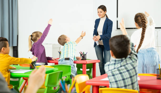istock Smiling teacher examining pupils at lesson 1481022936