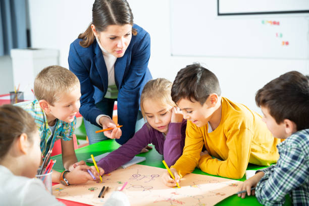 istock Teacher and happy schoolkids playing board game 1481022957