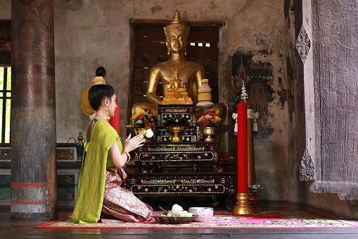 Ayutthaya, Thailand - August 26, 2023: a thai woman pray inside the Phanan Choeng temple.